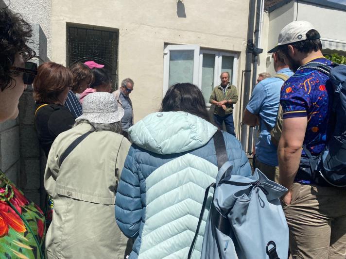 People in front of a house listening to a speaker